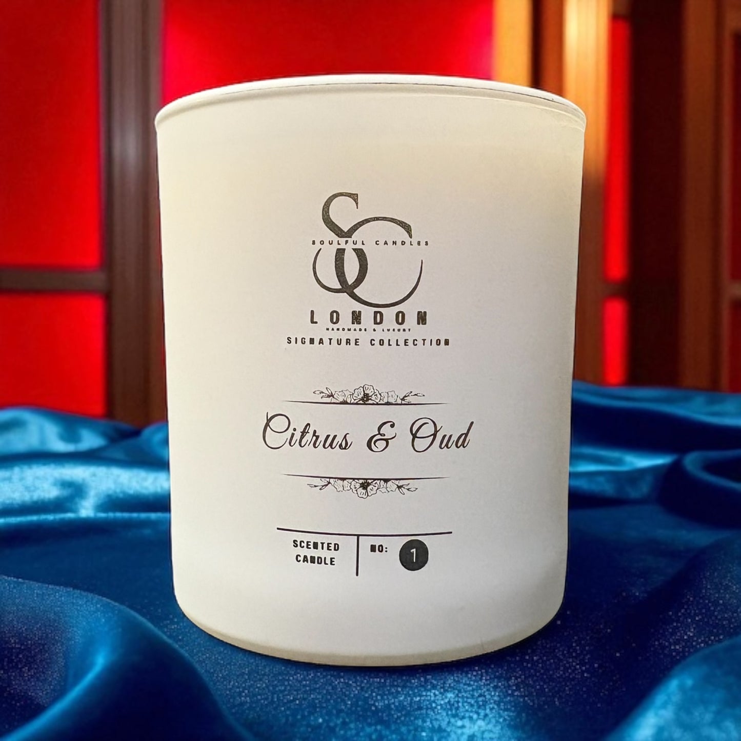 White candle with 'London' branding on a blue fabric background