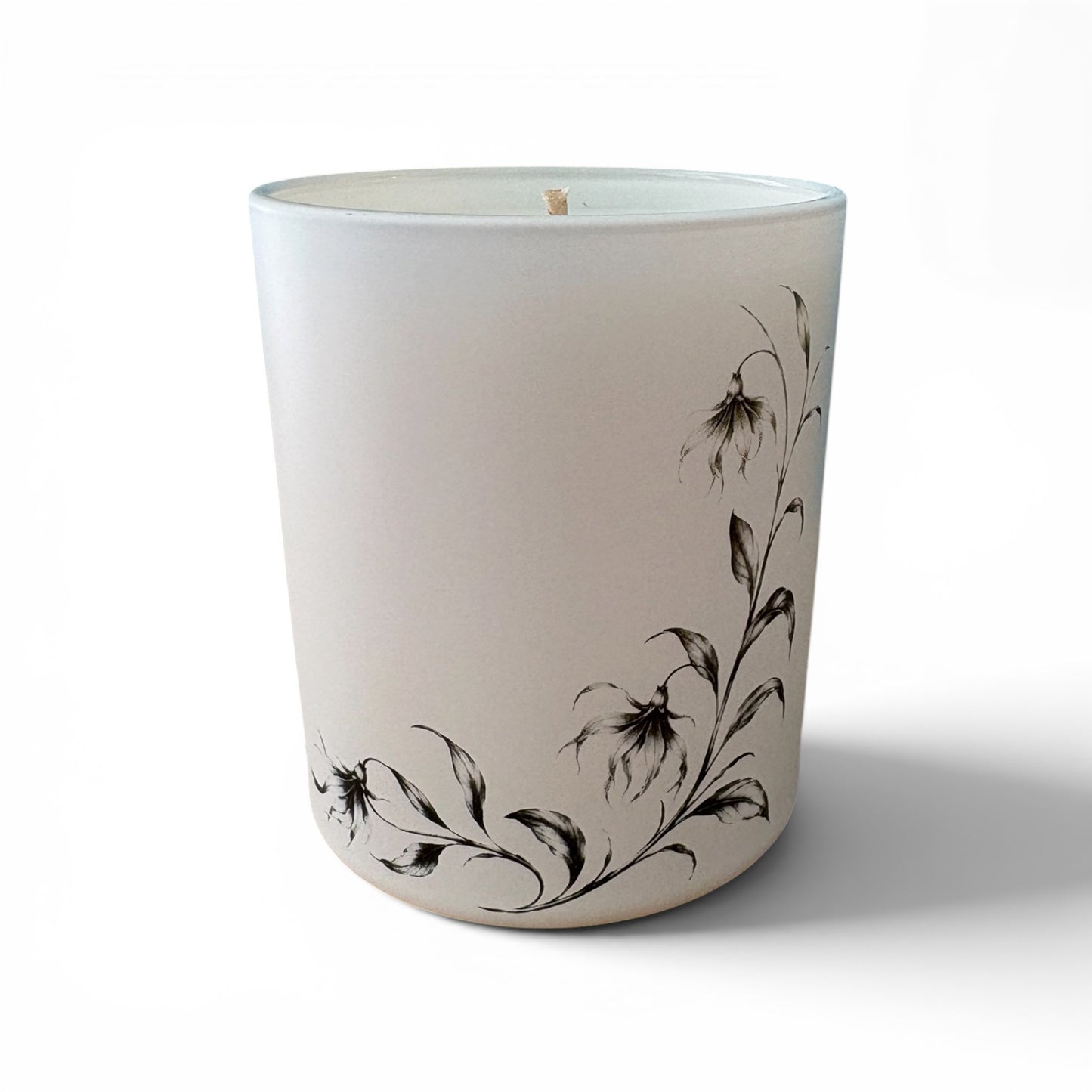 Matt white Ylang Ylang candle showing delicate botanical engravings around the glass