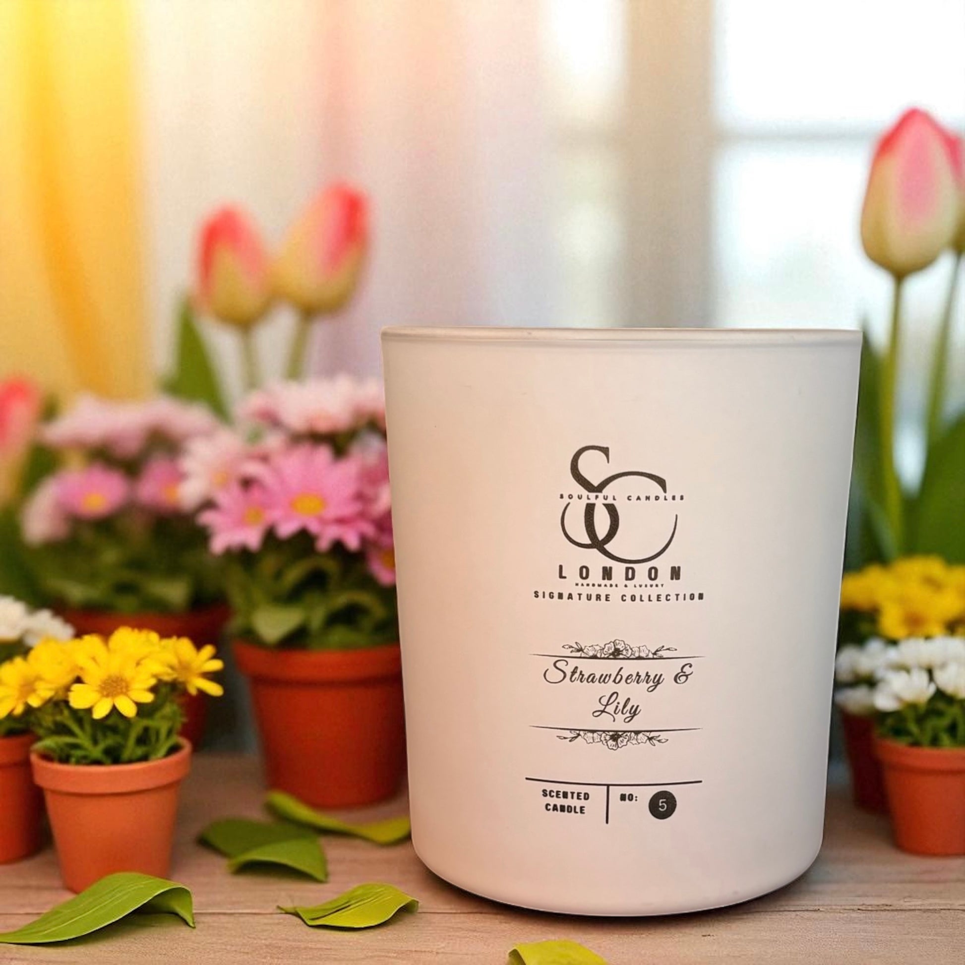 White candle with 'Scented Creations London' branding in a floral setting